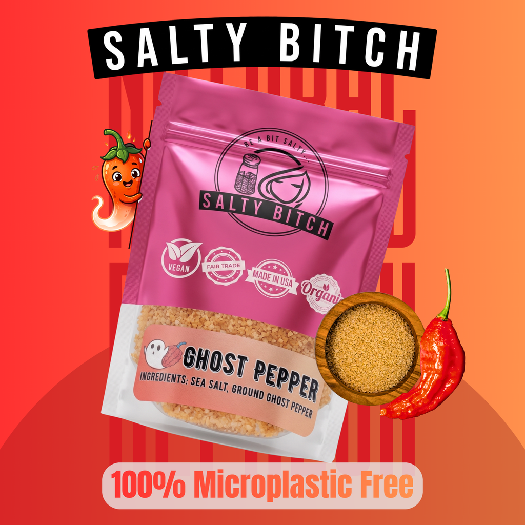 A stand-up pouch of Salty Bitch Ghost Pepper seasoning is shown on a bright orange-red graphic background with chili peppers and text reading 'SALTY BITCH,' 'GHOST PEPPER,' and '100% Microplastic Free.' The product itself is pink packaging with a clear lower section showing tan seasoning inside.