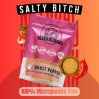 A stand-up pouch of Salty Bitch Ghost Pepper seasoning is shown on a bright orange-red graphic background with chili peppers and text reading 'SALTY BITCH,' 'GHOST PEPPER,' and '100% Microplastic Free.' The product itself is pink packaging with a clear lower section showing tan seasoning inside.