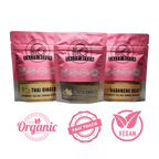 Three pink packages of 'Salty Bitch' seasoning with labels for organic, fair trade, and vegan certification on a white background.